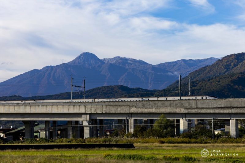 上越妙高の山並みを背景に走る北陸新幹線